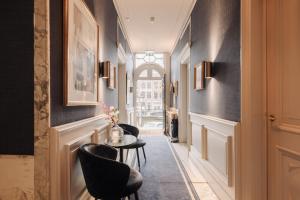 a corridor with a table and chairs in a hallway at Hotel 717 in Amsterdam