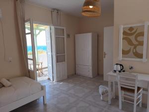 a room with a bed and a table and a door at Kathys Island Retreat in Adia