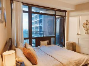 a bedroom with a bed with a large window at Gramercy Residences Cozy 1BR Suite with 600mbps & Free amenities City view in Manila +42 photos
