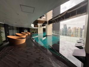 a swimming pool in a building with a view of the city at Gramercy Residences Cozy 1BR Suite with 600mbps & Free amenities City view in Manila