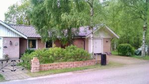 a small house with a brick fence in front of it at Pärlebo in Mellbystrand