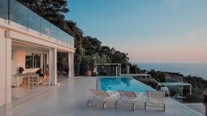 a house with a swimming pool and some chairs at Chalet Azzurro Capri in Anacapri