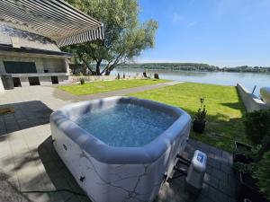 a bath tub sitting on a patio next to a body of water at Beli Dvor na Dunavu in Kovin