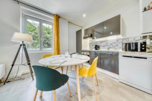 a kitchen with a white table and chairs at IDÉAL Pro & Familles, Billard, Borne Arcade, Netflix et Disney Plus, Jeu Bonus OFFERT in Saint-Étienne