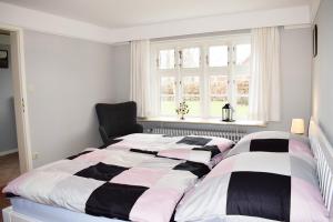 twee bedden in een slaapkamer met een raam bij Ferienhaus Haus Amsel Niebüll in Niebüll