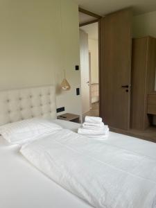 Una cama blanca con sábanas blancas y toallas. en Apartment La Baia, en Torri del Benaco 2 fotos más