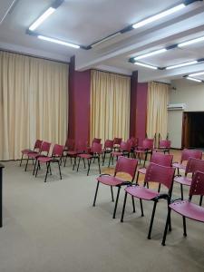 a room with red chairs in a room with curtains at Hotel Aguaý in Gualeguaychú