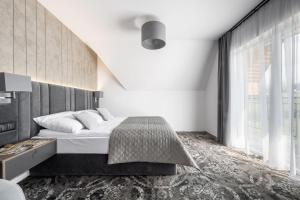 a bedroom with a bed and a large window at Sądelski Dwór Medical & SPA in Zakopane +123 photos