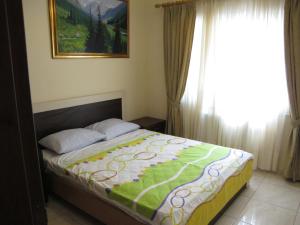 ein Schlafzimmer mit einem Bett mit einer grünen und weißen Decke in der Unterkunft Vergi Apartments in Pyla