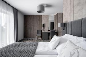 a bedroom with a large bed and a desk at Sądelski Dwór Medical & SPA in Zakopane