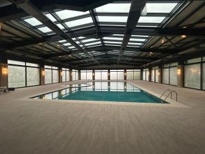 a large swimming pool in a large building with windows at Green Village HOTEL & SPA in Sis