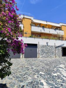 Un bâtiment avec un bouquet de fleurs violettes devant lui dans l'établissement Maison Blanche, à Varazze