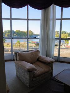 a living room with a couch and a large window at Hotel Aguaý in Gualeguaychú
