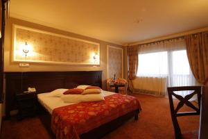 ein Hotelzimmer mit einem Bett und einem Fenster in der Unterkunft Nobillis - Carpathian Residence in Peştera
