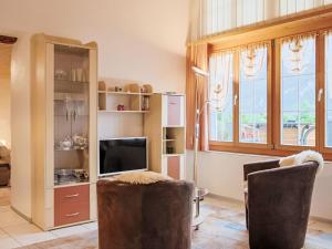 a living room with two chairs and a television at Apartment Am Brienzersee by Interhome in Brienz