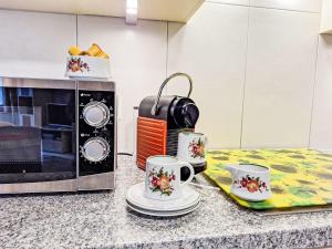 a kitchen counter with two cups and a microwave at Apartment Am Brienzersee by Interhome in Brienz +12 photos