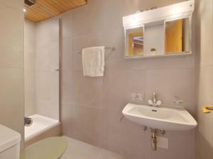 a bathroom with a sink and a toilet and a mirror at Apartment Eldorado 321 by Interhome in Verbier