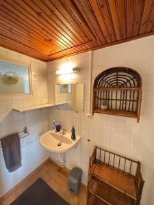 a bathroom with a sink and a mirror and a chair at La CONSTELLATION in LʼÉpine