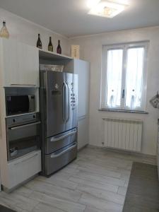 a kitchen with a stainless steel refrigerator and a window at Ľ angolo della quaquara in Genola