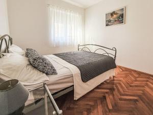 ein Schlafzimmer mit einem Bett und einem Holzboden in der Unterkunft Apartment Lucia by Interhome in Zadar