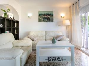 a living room with a white couch and a table at Holiday Home Delfines by Interhome in Benajarafe