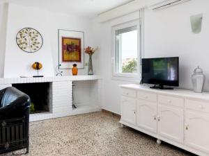 a white living room with a fireplace and a tv at Holiday Home Delfines by Interhome in Benajarafe