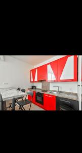 a kitchen with red cabinets and a table and chairs at Appartement 3 pièces in Nice