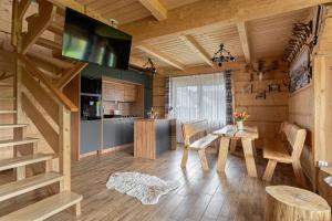 a kitchen and living room with a table and a television at Domek góralski Toporówka - Premium in Murzasichle +34 photos