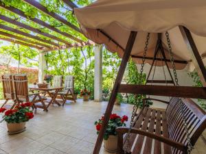 カンファナルにあるApartment Ivan & Tina-1 by Interhomeの木製の椅子と傘のあるパティオ