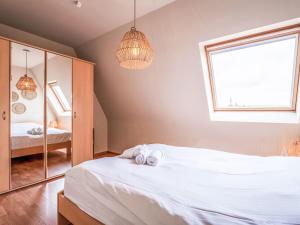 a bedroom with a white bed and a mirror at Apartment Residentie Irena app-302 by Interhome in Bredene