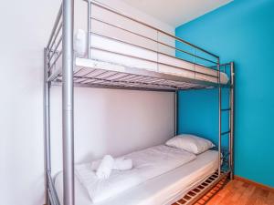 a bunk bed in a room with a blue wall at Apartment Residentie Irena app-302 by Interhome in Bredene