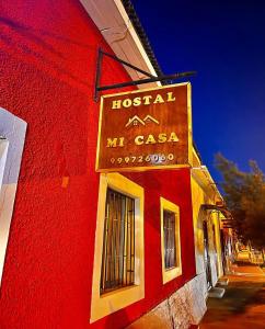 a red building with a hotel mci casa sign on it at Hostal Mi Casa in Canela Baja +10 photos