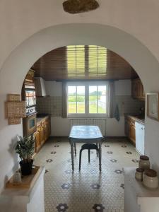 a kitchen with a table in the middle of a room at La CONSTELLATION in LʼÉpine
