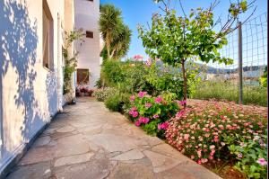 a stone walkway next to a house with flowers at Kostas Apartments in Stalís