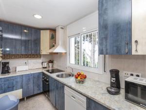 a kitchen with blue cabinets and a bowl of fruit on the counter at Holiday Home Mercury by Interhome in Lloret de Mar