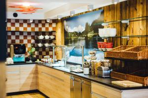a kitchen with a large picture of a lake at Der Dorfwirt in Rechberg
