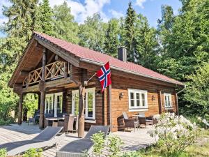 格罗森克内滕Chalet Trollstua by Interhome的甲板上悬挂着旗帜的小木屋