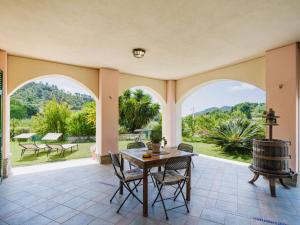 eine Außenterrasse mit einem Tisch, Stühlen und einem Fass in der Unterkunft Holiday Home Casa Melograno by Interhome in Sestri Levante