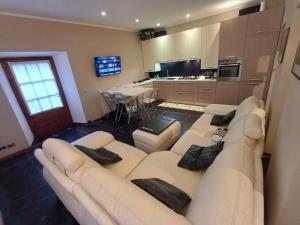 a living room with a white couch and a kitchen at Casa Sinetta Como Lake in Acquaseria
