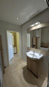 Un baño con lavabo y un espejo grande. en Apartamenty Morze Wygody, en Międzywodzie