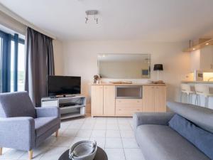 a living room with a couch and a tv at Studio Studio by Interhome in Bredene +21 photos