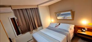 a hotel room with a bed and a window at Flat da Claudia in Fortaleza