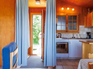 a kitchen with blue curtains in a room with a table at Chalet Tsamandon 22 by Interhome in Nendaz