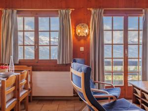a dining room with a table and chairs and windows at Chalet Tsamandon 22 by Interhome in Nendaz