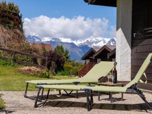 a picnic table and a bench with mountains in the background at Chalet Tsamandon 22 by Interhome in Nendaz