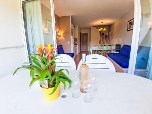 - une table blanche avec une bouteille de vin et une plante dans l'établissement Apartment Les Rivages de Coudoulière-16 by Interhome, à Six-Fours-les-Plages