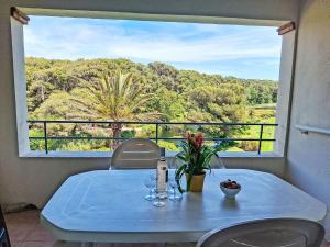 - une table avec des verres à vin et des fleurs sur le balcon dans l'établissement Apartment Les Rivages de Coudoulière-16 by Interhome, à Six-Fours-les-Plages