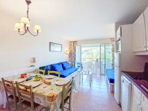 Il comprend une cuisine et un salon avec une table et un canapé bleu. dans l'établissement Apartment Les Rivages de Coudoulière-16 by Interhome, à Six-Fours-les-Plages