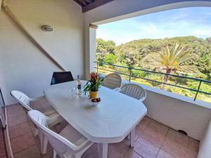 une table blanche et des chaises sur un balcon avec vue dans l'établissement Apartment Les Rivages de Coudoulière-16 by Interhome, à Six-Fours-les-Plages