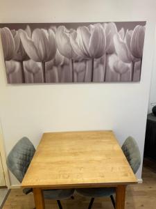 a wooden table and chairs with a painting on the wall at Voorstraat 30 Studio in Colijnsplaat